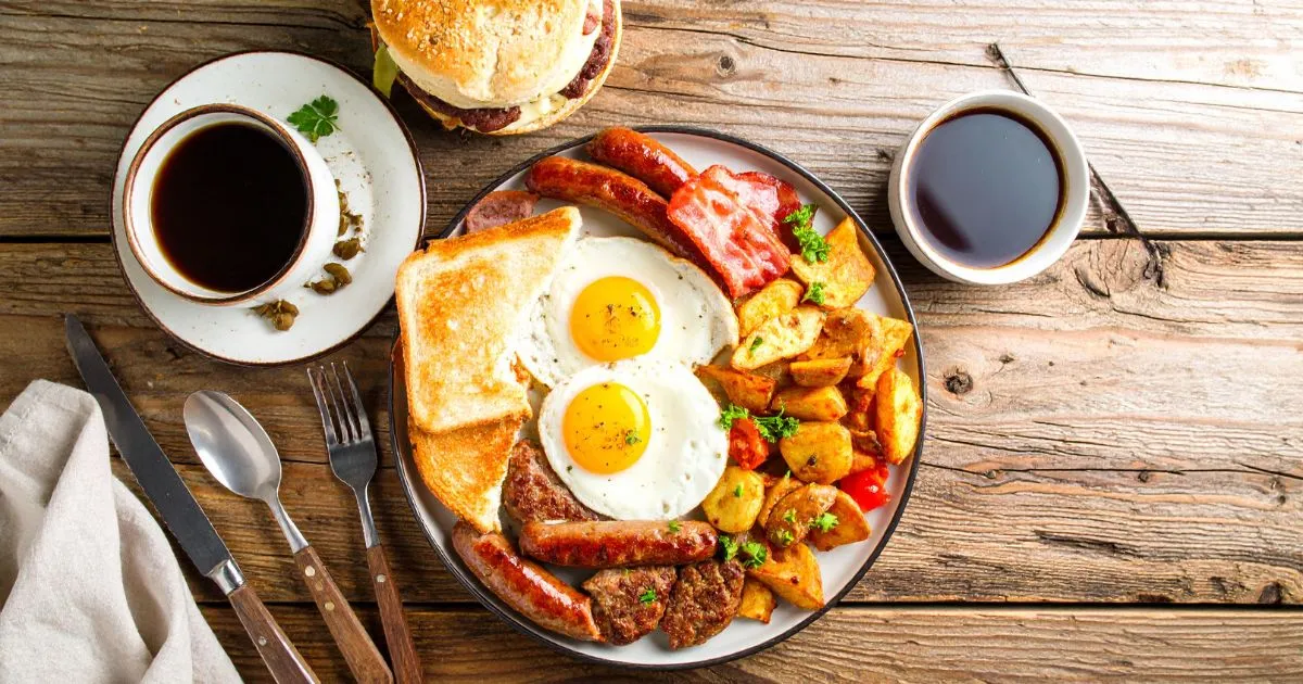 Homemade deer meat breakfast sausage served with eggs, hash browns, and toast on a rustic wooden table.