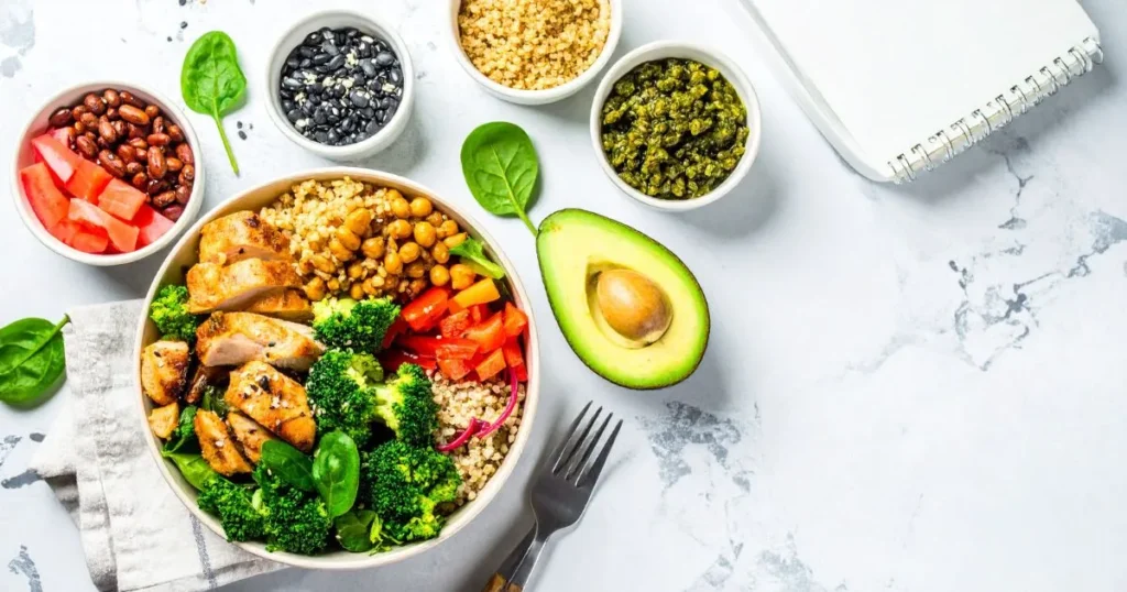 Clean Bulk Meal Plan setup with meal prep containers filled with lean protein, complex carbs, and vegetables, alongside a food scale and fitness planner on a kitchen counter.
