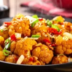 Homemade Chinese cauliflower stir-fry with garlic, soy sauce, and sesame oil in a wok