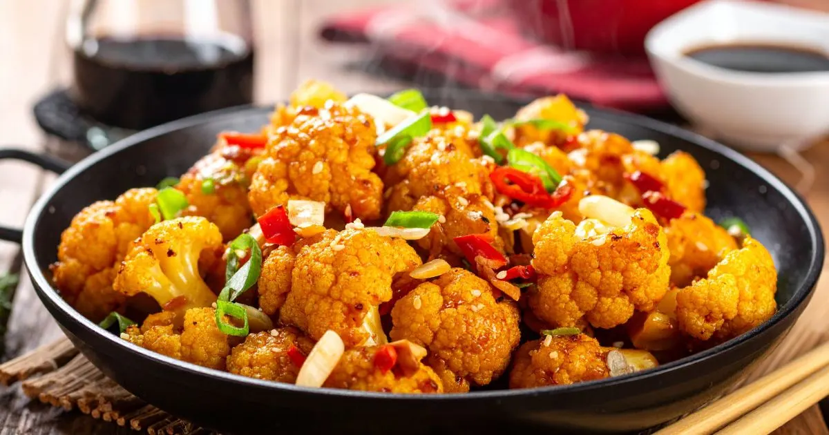 Homemade Chinese cauliflower stir-fry with garlic, soy sauce, and sesame oil in a wok