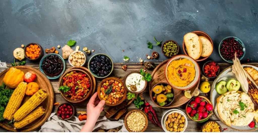 A colorful assortment of traditional Native American foods, including corn, beans, squash, wild rice, berries, and nuts, beautifully arranged on rustic wooden platters and clay bowls, highlighting the diversity and heritage of Indigenous cuisine.