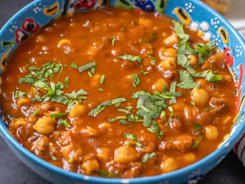 Bowl of traditional Moroccan Harira soup with lentils and chickpeas