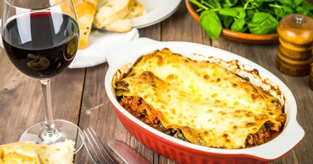 A close-up of a freshly baked lasagna with golden cheese and visible layers, representing an Authentic Lasagna Bolognese Recipe.