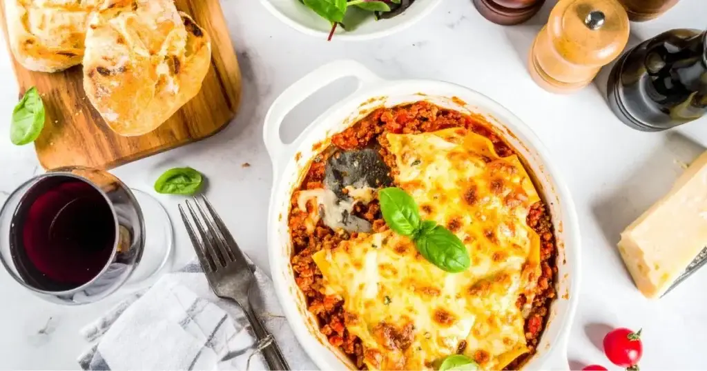 A close-up of a freshly baked lasagna with golden cheese and visible layers, representing an Authentic Lasagna Bolognese Recipe.