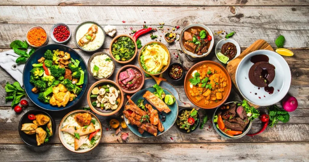 Assorted keto Instant Pot recipes including low-carb chicken, beef, vegetables, and dessert dishes, served in bowls on a rustic kitchen table